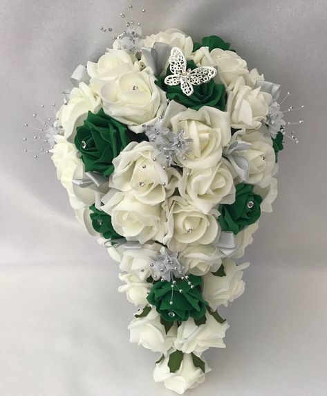 Ivory & emerald green bouquets sets All bouquets and wands each come with a silver butterfly on. These bouquets are made with Ivory & emerald green quality foam roses  With silver flowers sprays around them with crystal pins in some of the flowers centres and added silver looped ribbon The  Quality roses used are made from foam  Available in 3 different sizes with matching buttonholes ,wands and wrist corsages hair combs  With matching cake topper in single or 3 tier  New to this range are  Matc Emerald Green And Silver Wedding, Green And Silver Wedding, Wedding Cake Emerald Green, Green Theme Wedding, Emerald Wedding Colors, Green Bouquets, Silver Wedding Decorations, 16th Wedding Anniversary, Princess Frog