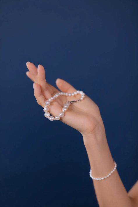 Person Holding a Pearl Bracelet · Free Stock Photo Hand Holding Necklace, References Drawing, Elegant Pearl Jewelry, Modern Pearl Jewelry, Jewelry Product Shots, Pearl Jewelry Design, Product Shots, Button Bracelet, Pose References