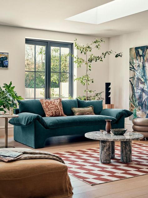 A teal sofa is a striking and vibrant centerpiece for any living room. Its rich and deep shade of blue-green adds a sense of depth and character to the space. The bold color instantly grabs attention and infuses the room with a refreshing energy. Whether placed against a neutral backdrop to create a focal point or surrounded by complementary or contrasting colors, the teal sofa exudes a sense of elegance and style. Its versatility allows for various design options, from coastal-inspired decor Navy Velvet Couch, Navy Couch Living Room, Soho Warehouse, Blue Sofa Decor, Navy Sofa Living Room, Teal Sofa Living Room, Blue Velvet Sofa Living Room, Navy Couch, Relaxed Glamour