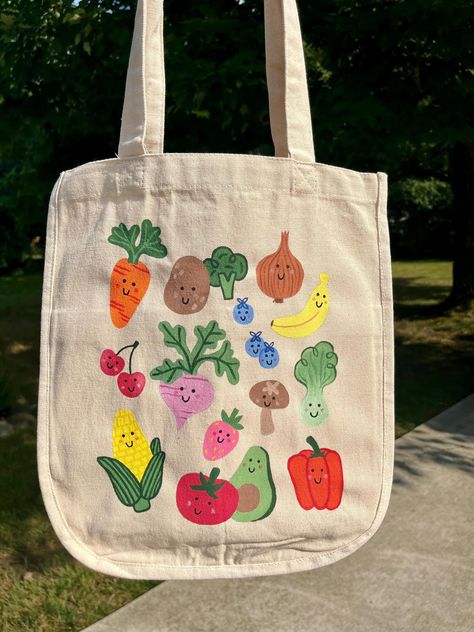 -Hand-painted canvas tote bag -fruits & veggies -Six pockets! Length: 13 3/4" Width: 13 1/4" Thickness: 6 1/2" Handle Drop Length: 10" Cute Grocery Bags, Paint Tote Bags Ideas, Tote Bag Craft Ideas, Painting Canvas Bags Ideas, Tote Bag Painting Party, Painted Canvas Tote Bags, Tote Bag Inspo Painting, Painting Tote Bags Aesthetic, Cute Painted Tote Bags