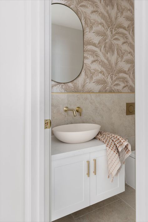 This bathroom features a white shaker vanity, brushed brass tapware and beige palm tree wallpaper. Hamptons Powder Room, Modern Hamptons Bathroom, Hamptons Wallpaper, Hamptons Style Bathroom, Coastal Powder Room, Bathroom Splashback, Abi Interiors, Tub Design, Hamptons Style Homes