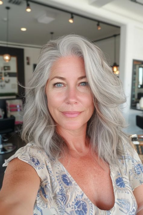 Smiling woman with long gray hair in a well-lit room. White Gray Hair With Lowlights, Blonde With Grey Hair, White Hair Blending, Grey Blending Highlights Blondes, Grey Locks, White Hair With Lowlights, White Hair Highlights, Dimensional Layers, Silver Hairstyles