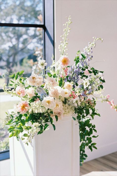 Stylish florals for weddings + events, and a Daily Delivery Flower Shop that allows us to give back to our community through "Floral Support." Based in Austin, Texas. The Arlo | Stems Floral Design | Sarah Stipanovich Photography Bright, modern indoor ceremony space with pastel floral arrangements on pedestals. Hints of pink, purple, blue and peach flowers. Pedestal Flower Arrangements Wedding, Spring Wedding Flower Centerpieces, Types Of Floral Arrangements, Spring Wedding Arrangements, Faux Floral Arrangement Wedding, Wedding Arrangements Ceremony, Pastel Spring Flowers, Flower Arrangements For Wedding Ceremony, Wedding Alter Floral Arrangements