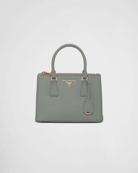 The Prada Galleria bag, which exemplifies Prada's centennial excellence in luxury leather goods, becomes a reflection of the brand's modernity and stylistic identity that seeks to interpret kaleidoscopic contemporaneity through a pragmatic design and structured lines. The accessory, presented in the small version, is made of iconic Saffiano leather that was patented by the founder of the brand and features a crosshatch texture and waxed finish. The Prada Galleria bag, named after the historic Prada Galleria Bag, Gucci Marmont Bag, Bottega Veneta Handbag, Galleria Vittorio Emanuele Ii, Leather Key Ring, Prada Galleria, Metal Lettering, Prada Collection, Lettering Logo