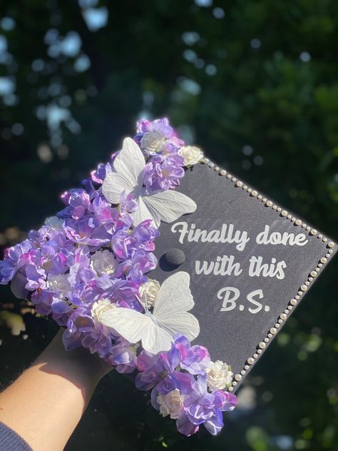 graduation cap design with purple & white flowers, white butterflies, pearls, “finally done with this BS” quote, bachelor’s of science, exercise science, kinesiology Done With This Bs, Grad Cap With Butterflies, Pearl Graduation Cap Ideas, Graduation Cap Designs Kinesiology, Graduation Cap With Butterflies, Finally Done With This Bs Graduation Cap, Graduation Cap Designs With Butterflies, Cap Decoration Graduation Butterfly, Grad Cap Ideas Butterflies