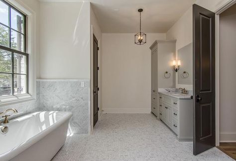 Dark gray bi-fold doors open to a gray bathroom featuring his and her washstands painted gray topped with marble under frameless beveled mirrors illuminated by Restoration Hardware Modern Taper Sconces with Linen Shades. Restoration Hardware Modern, Gray Doors, Grey Doors, Cottage Bathroom, Bathroom Closet, Transitional Bathroom, White Marble Countertops, Bathroom Wall Tile, Grey Bathrooms