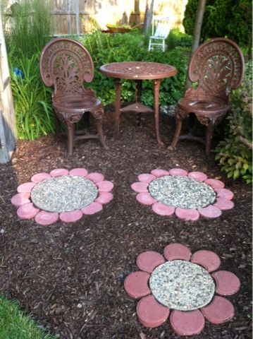 Paver Flowers - this would be fun with custom middles the kids make (same size as some of the aggregate pavers) with colored glass beads. Fun keepsake stepping stones adding a splash of color in the flower beds. Stepping Stone Flowers, Sunflower Stepping Stones Diy, Cute Stepping Stone Ideas, Playhouse Flower Bed, Stone Flowers Garden Art, Sunflower Pavers, Fairy Stepping Stones, Rock Flower Path, Sunflower Stepping Stone Ideas