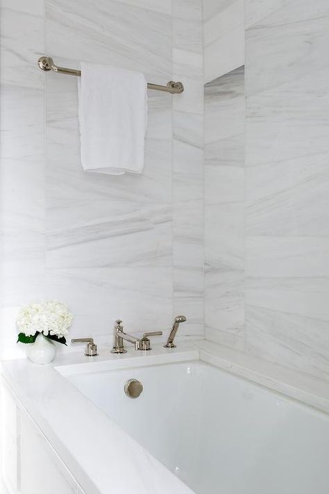 A polished nickel towel bar is fixed to mixed size white marble wall tiles above a drop-in bathtub fitted with a polished nickel tub filler mounted to a marble deck. تصميم دورة مياه, Luxury Spa Bathroom, Marble Bathtub, Spa Luxury, White Marble Bathrooms, Mold In Bathroom, Bathroom Remodel Cost, Drop In Bathtub, Bathtub Tile