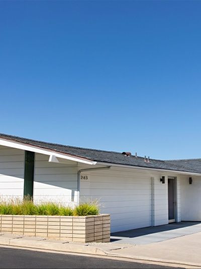 This Mid-Century Bungalow Doesn’t Have a Single 90-Degree Angle – domino White Mid Century Modern Exterior, Midcentury Home Exterior, Midcentury Cottage, White House Exterior, Mid Century Bungalow, White Mid Century Modern, Mid Century Modern Exterior, White Exterior Houses, Round Furniture