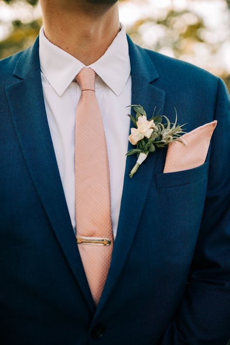 Blue suit with pink tie and tie clip - groom's attire · Rock n Roll Bride Blue Suit Peach Tie, Navy Blue And Peach Groomsmen Suits, Dark Blue Suit With Pink Tie, Groom Blue Suit Pink Tie, Navy Suit Peach Tie, Navy Blue Suit Beach Wedding, Blue Suit Pink Tie Wedding, Navy Blue Suit Wedding Groom Attire Blush Pink, Ties With Blue Suits