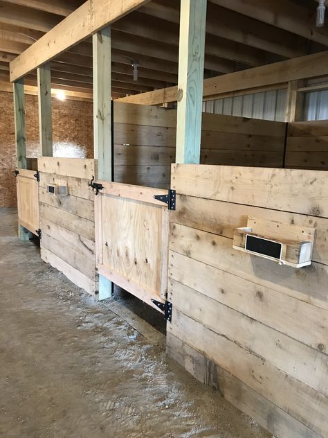 The stalls in our new horse barn with brush holders on each stall and chalk board on the front to write their names. It will also have hooks under the holder for their halter. Wood Horse Stalls, Simple Horse Stalls, Stall Door Ideas, Diy Stall Fronts, Horse Stall Walls, Horse Barn Stalls Ideas, Horse Stall Design, Small Stable Ideas, Horse Stall Ideas Cheap