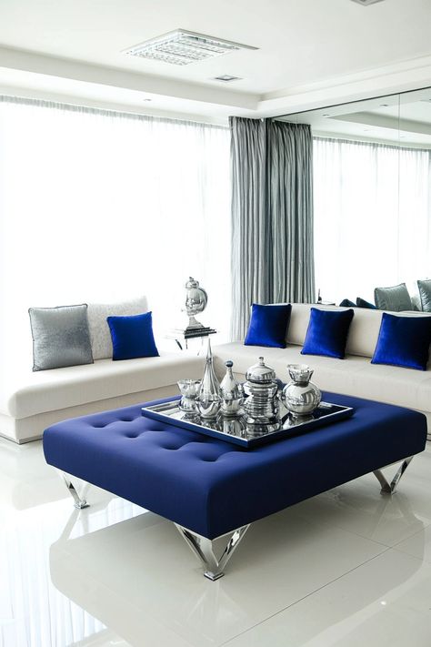 Infuse your living room with a touch of luxury with a blue and silver color scheme.  These 26 decorating ideas offer inspiration for a sophisticated and elegant space. Discover captivating wall treatments, stunning furniture selections, and elegant accessories to create a living room that exudes class and comfort. Blue Silver Living Room Decor, Silver Living Room Decor Ideas, Blue And Silver Living Room, Silver Living Room Ideas, Silver Living Room Decor, Blue Living Rooms, Upholstered Window Seat, Blue Bookshelves, Blue Leather Sofa