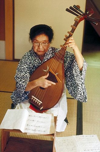 Woman playing a biwa, traditional japanese musical instrument. This lute is usually made of rosewood, quince, or mulberry. Its strings are made of silk stretched over frets of bamboo and wood. It has its origins in China, Korea, and India over a thousand years ago. Biwa Japanese Instrument, Biwa Instrument, Beatles Help, Female Guitarists, Musical Instruments Drawing, Music Institute, The Beatles Help, Real Spiders, People Reference