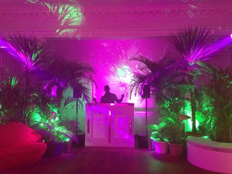 DJ booth set in jungle themed party. Jungle Dj Booth, Techno Theme Party, Dj Booth Decoration, Neon Jungle Party Decorations, Neon Dj Booth, Tropical Dj Booth, Techno Party Decoration, Dj Themed Birthday Party, Tropical Neon Party