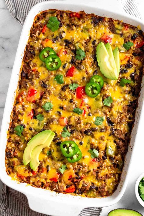 Comfort food doesn’t get much better than this beef burrito casserole. Seasoned ground beef, veggies, rice, and beans are baked together and then topped with melty cheese for a delicious healthy casserole recipe. High protein, gluten-free, and great for meal prep. Hamburger Burrito Casserole, Casserole Recipes High Protein, Easy Chicken Burrito Casserole, Deconstructed Burrito Casserole, High Protein Ground Beef Casserole, Beef And Bean Taco Casserole, Healthy Baked Casserole Dinners, Mexican Casserole With Rice, Lunch Ground Beef