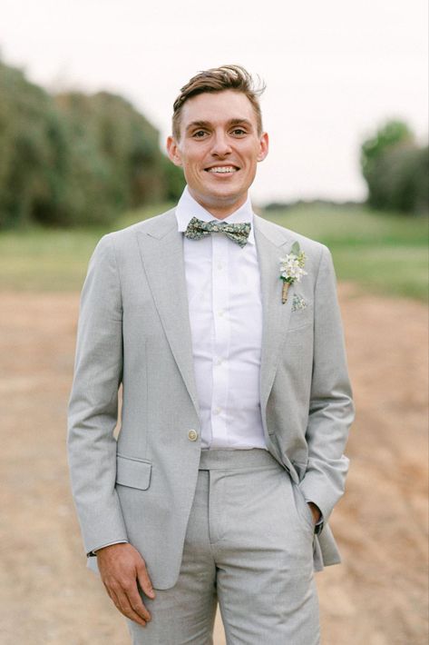 A groom wearing a grey suit with a custom bowtie Mens Suit And Tie, Groomsman Boutonniere, Mens Formalwear, Bow Tie Suit, Mens Bowtie, Groom Bowtie, Hunter Valley Wedding, Groomsmen Boutonniere, Groom Accessories