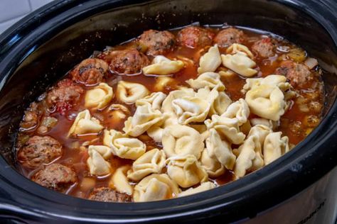 This easy Italian-inspired Crock Pot Meatball and Tortellini Soup is an all-in-one slow cooker meal that is made with pre-made meatballs and cheese tortellini! Italian Meatball Soup Crockpot, Meatball And Tortellini Soup, Meatball Soup Crockpot, Meatball Tortellini, Tortellini Soup Crockpot, Meatball Tortellini Soup, Meatballs And Cheese, Crock Pot Tortellini, Cheese Tortellini Soup