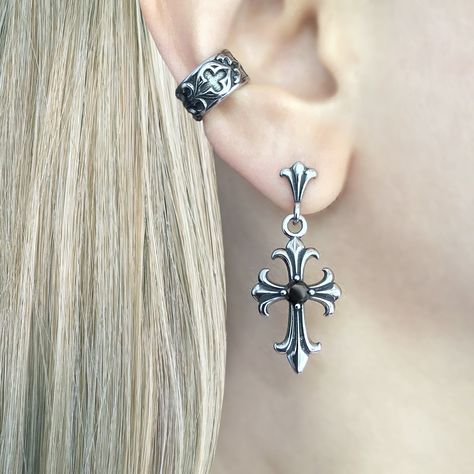 Gothic Cross Earring, a striking piece of jewelry that embodies the essence of gothic style and dark elegance. Crafted with meticulous attention to detail, this earring is designed to make a bold statement and add a touch of mystique to any outfit. Sold as Single or Pair Material : 316 Stainless steel Set with Black and Clear Cubic Zirconia Size: 38 mm long Closure: Butterfly push back Listing for pair of earrings only Elegant Gothic Jewelry, Goth Ear Stack, Elegant Piercings, Moodboard Jewelry, Gothic Moodboard, Gothic Piercings, Cross Piercing, Goth Piercings, Alt Earrings