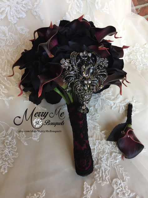 A new twist on this bouquet design uses Black silk roses and dark Plum calla lilies with a statement brooch in Black. The handle is wrapped in Burgundy satin and Black lace. I love this one #blackbouquet #plumbouquet #uniquebouquet #custombouquets #bouquets Black And Burgundy Gothic Wedding, Black And Plum Wedding, Wedding Bouquets Gothic, Gothic Wedding Flowers Bridal Bouquets, Burgundy And Black Bridal Bouquet, Gothic Bridesmaid Bouquet, Burgundy Black Wedding, Dark Red And Black Bouquet, Burgundy And Black Wedding