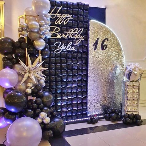 Glam up your 16th birthday party setup with a spectacular silver and black backdrop arrangement. Adorn your backdrop stand with silver sequin covers to impart a sparkling allure all around. Furthermore, adorn a tall gold stand with black and silver balloons along with silver star-shaped balloons for a luxurious touch. 50th Birthday Balloons, Event Decor Ideas, Party Decorations Table, Space Party Decorations, Birthday Decorations For Men, Shimmer Wall, Happy 16th Birthday, Diy Balloon Decorations, Birthday Party Theme Decorations