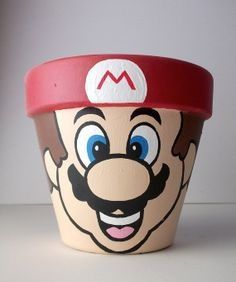 Mario flower pot Painted Flower Pot, Home Garden Ideas, Clay Pot Projects, Flower Pot People, Clay Pot People, Super Mario 3d, Flower Pot Art, Terra Cotta Pot Crafts, Flower Pot Design