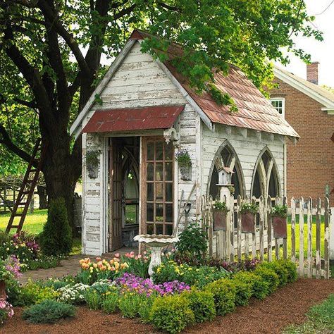 Gothic arched windows add to the antique feel of this garden shed. Stamped-metal roofing and hanging planters on the fence repeat the arched shape. A row of boxwoods brings order and definition to the entry garden. Garden Shed Decor, Garden Sheds Ideas, Shed Inspiration, Sheds Ideas, Cottage Garden Sheds, Diy Sheds, She Shed Ideas, Shed Decor, Gothic Garden