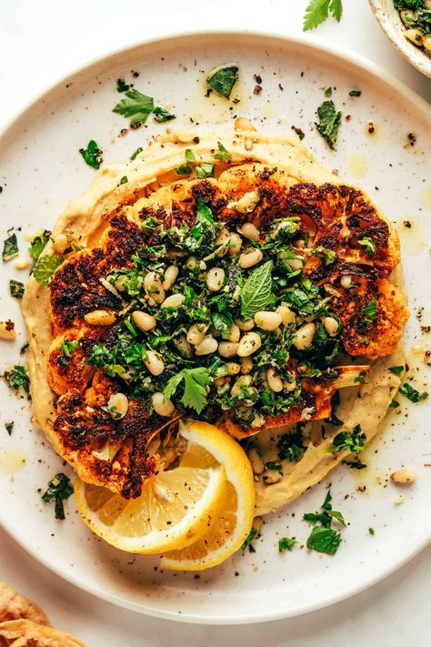 Zesty cauliflower steaks are served over hummus and sprinkled with a lemon-mint pine nut gremolata. A simple, healthy and absolutely delicious dinner recipe that also happens to be vegetarian, vegan and gluten-free. | gimmesomeoven.com Vegeterian Dishes, Veggie Mains, Cauliflower Steak, Roasted Cauliflower Steaks, Main Recipes, Meat Meals, Pasta Meals, Cauliflower Steaks, Gimme Some Oven