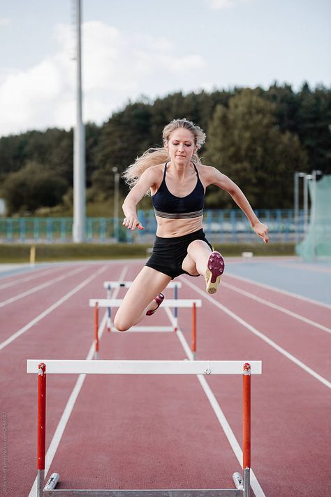 Professional confident track and field female athlete jumping over hurdle while training and preparing for obstacle race competition at stadium Hurdling Aesthetic, Track Action Shots, Hurdles Aesthetic, Jumping Hurdles, Jump Over, Track And Field Aesthetic, Track Hurdles, Track Aesthetic, Hurdles Track