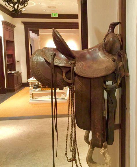 Wall mounted vintage saddle at Ralph Lauren Saddle Ideas Home Decor, Saddle Decor Ideas House, Saddle Decor, Bush Retreat, Ralph Lauren Western, Fancy Farm, Cattle Brands, Entry Ways, Lake Cabin