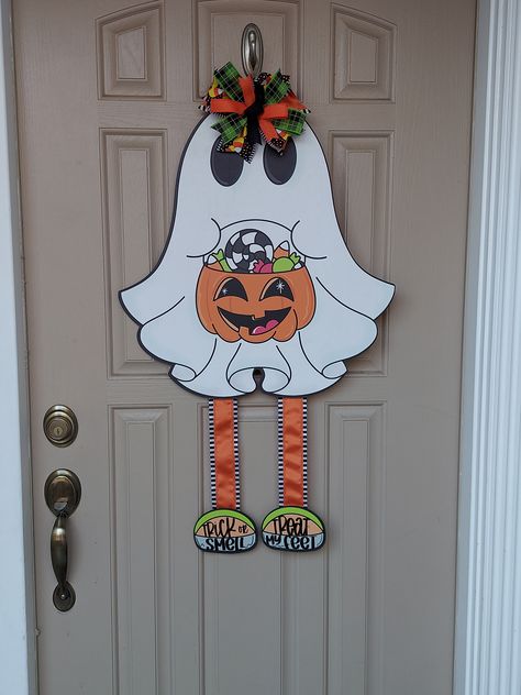 Don't have the room for a large full wreath? This adorable ghost is perfect for in between a storm door, with her cute little ribbon legs and shoes, this cutie is great for Halloween, stop by fallingbranchdesigns.com for more Fall decor. Ghost Holding A Pumpkin, Ghost Door Hanger, Ghost Door, Halloween Wood Crafts, Halloween Door Hangers, Chicken Decor, Halloween Front Porch, Halloween Crafts Decorations, Shelf Sitters