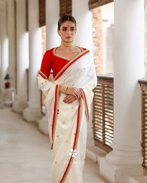 Trending Bengali Bridal Saree Designs For A Surreal Bridal Look White Saree Red Border Bengali, White Saree Red Border, Bengali Bridal Saree, Bengali Bridal Look, Bridal Saree Designs, Bengali Wedding Dress, Indian Cocktail Dress, White Saree Blouse, Red And White Saree