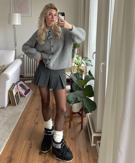 Grey sweater cardigan and mini pleated skirt outfit with black moon boots aesthetic outfit inspo Grey Moon Boots Outfit, Grey Pleat Skirt Outfit, Grey Miniskirt Outfits, Moon Boots Outfit Skirt, Grey Pleated Skirt Outfit Winter, Grey Skirt Winter Outfit, Gray Sweater Aesthetic, Mini Grey Skirt Outfit, Grey Short Skirt Outfit