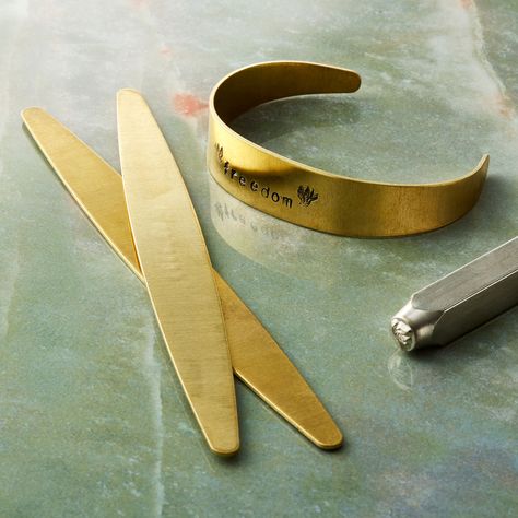 "Get the ImpressArt® Brass Tapered Bracelet Blanks at Michaels. com. These tapered brass bracelets from ImpressArt can be personalized the way you want. These tapered brass bracelets from ImpressArt can be personalized the way you want. Simply stamp these blank bracelets with beautiful patterns or designs to enhance their charm. Details: Gold colored 0.74\" x 2\" x 8\" (1.879cm x 5.08cm x 20.32cm) 16 g 3 blanks Brass | ImpressArt® Brass Tapered Bracelet Blanks in Gold | 2\" x 8\" | Michaels®" Bracelets At Home, Metal Stamping Kit, Metal Stamping Diy, Bracelet Blanks, Stamps Art, Hand Stamped Metal, Handstamped Bracelet, Metal Letter, Stamped Bracelet