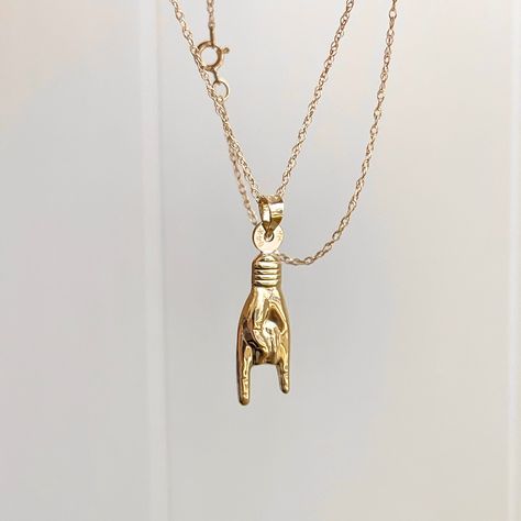 "14KT yellow gold 3D Italian Mano Cornuto hand symbol/ good luck pendant charm on a 14KT Yellow Gold Cable Chain Necklace The charm represents a hand gesture in which the index and little fingers are extended while the middle and ring fingers are curled into the palm. The reference is to the horned head of an animal. The Mano Cornuto is often worn to provide protection from the evil eye or bad energies. *PLEASE NOTE: We carry 3 sizes of this mano hand necklace. This listing is for the MEDIUM siz Pride Necklace, Chainmail Necklace, Hand Symbols, Saint Jewelry, Hand Gesture, Hand Necklace, Cable Chain Necklace, Small Charms, Oval Pendant