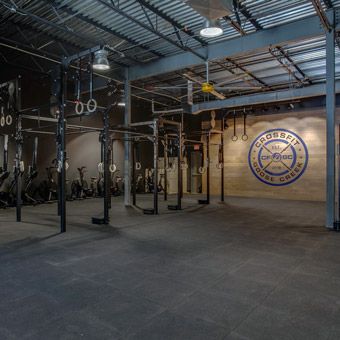 Shortly after purchasing the mats and before officially opening the doors to CrossFit Goose Creek, a gym owner from Nashville who was in a similar situation came over to witness the test.  “I was slamming a 135-pound barbell as hard as I possibly could from overhead,” Gray said, and the other gym owner said the sound was barely audible.  “We’ve been crashing weights on it for almost a month now, and I’ve been talking with my neighbors. They’re like, ‘We don’t hear anything,’” Crossfit Gym Design Ideas, Crossfit Box Design, Crossfit Gym Design, Warehouse Gym Design, Crossfit Garage Gym, Rubber Gym Flooring, Warehouse Gym, Boutique Gym, Gym Flooring Rubber