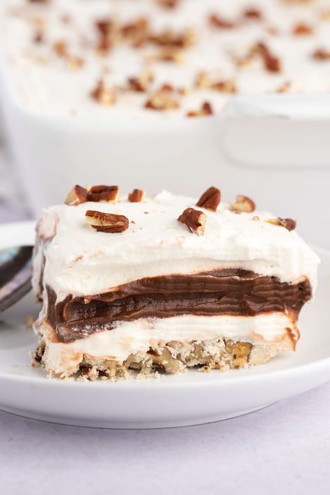 This easy chocolate delight recipe really lives up to its name, with a pecan crust, cheesecake and chocolate pudding filling, and whipped cream on top. Pecan Crust Cheesecake, Chocolate Delight Dessert, Chocolate Delight Recipe, Delight Recipes, Delight Dessert, Chocolate Pudding Desserts, Pecan Crust, Pecan Desserts, Chocolate Lasagna