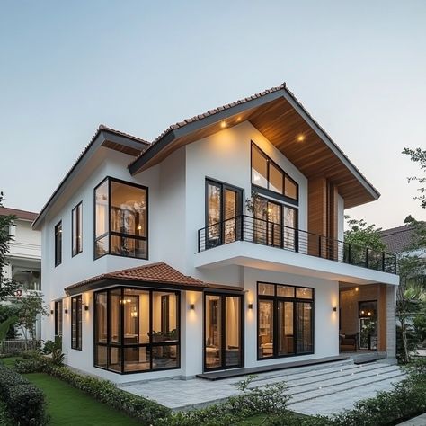 This modern duplex house showcases the beauty of simplicity, with a white facade and dark window frames enhanced by warm wooden details. The sloped roof and tropical landscaping add to the home’s inviting charm, especially under the soft evening light. #ModernSimplicity #DuplexLiving #TropicalDesign #WarmAccents #EveningCharm Dark Window Frames, Modern Duplex House, White Facade, Japan House Design, Tropical Villa, Dark Window, Sloped Roof, Japan House, Dark Windows