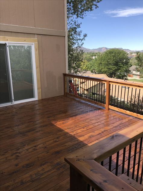 Cedar deck stained in Superdeck Canyon Brown. Cedar railing with black aluminum balusters. Deck Stain Colors For Tan House, Brown Deck, Deck Stain With Black Railing, Trending Deck Stain Colors, Stained Deck With Black Spindles, Stain Deck Colors, Walnut Deck Stain, Brown And Black Deck, Front Porch Stain Colors