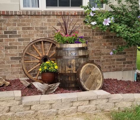 Barrel Outdoor Decor, Decorating With Wagon Wheels Front Yards, Wagon Wheel Porch Decor, Rustic Outdoor Landscaping Ideas, Wagon Wheel Outdoor Ideas, Outdoor Wagon Wheel Decor, Rustic Front Yard Landscaping Ideas Wagon Wheels, Whiskey Barrel Porch Decor, Whiskey Barrel Outdoor Decor