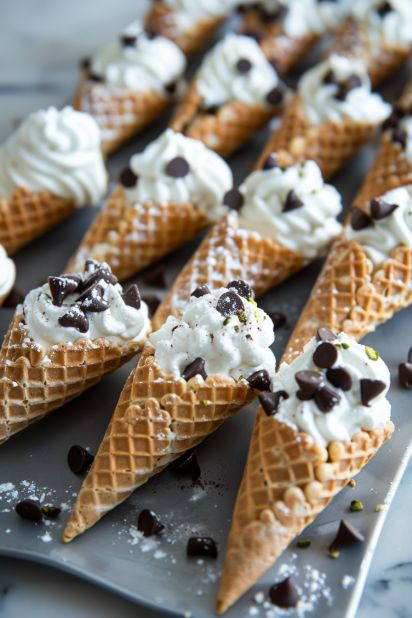 Discover the joy of making Chocolate Chip Cannoli Cones with this simple recipe. It combines ricotta, mascarpone, and chocolate chips in a crunchy cone for a perfect blend of flavors. Ideal for parties, gatherings, or a sweet treat anytime. Try it now and impress your friends and family! Cannoli Cones, S’mores Cones, Mini Ice Cream Cone Desserts, Cannoli Chocolate Chip Cookie Cups, Cannoli Cookie Cups, Chocolate Cannoli Filling, Waffle Cone Cannoli, Pie Dip, Cone Dessert