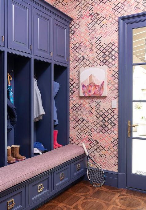 Contemporary pink and blue mudroom features blue built-in lockers with bench and a pink cushion and overhead cabinets accented with brass pulls, pink and blue wallpaper and brown floors. Lockers With Bench, Blue Mudroom, Mudroom Shelves, Pink And Blue Wallpaper, Beadboard Trim, Contemporary Laundry Room, Built In Lockers, Blue Shelves, Oak Floating Shelves