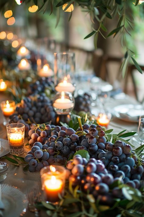 ✨ Elevate your wedding ambiance with a centerpiece that whisks you away to the rolling hills of Tuscany. Experience the charm of Italy as grape vines & olive branches intertwine with the warm glow of candles on your special day. #WeddingInspiration #TuscanWedding #RomanticDecor #WeddingIdeas #CountryChic #RusticElegance #GrapeAndOlive #CandlelightMagic Let the light guide your love story. Vine Table Decor, Italian Inspired Centerpieces, Wine Dinner Centerpieces, Grape Centerpiece Wedding, Wine Cork Table Decor, Grapes Centerpiece Wedding, Tuscany Wedding Table Decor, Grape Wedding Decor, Italian Centerpieces Table Decorations Tuscan Style