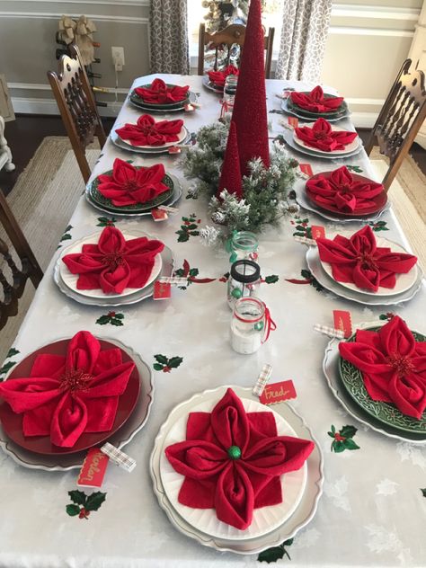 Setting the Christmas table can be as easy as folding your napkins into poinsettia flowers. And they’re easy to make! Napkin Folding For Christmas Table, Best Christmas Table Decorations, Napkin Cloth Folding, Christmas Napkin Decorations, How To Fold Dinner Napkins Holidays, Folding Cloth Napkins For Christmas, Napkins Folding Ideas Christmas, Folded Napkins For Christmas, Christmas Tree Folded Napkins