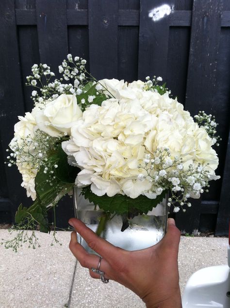 white hydrangea, white rose, and babysbreath centerpiece in clear glass cube (wedding) Hydrangea White Centerpiece, Inexpensive Floral Centerpieces Simple, Hydrangea Simple Centerpiece, Hydrangea Centre Pieces, Green And White Hydrangea Centerpiece, Wedding Decor Hydrangea, Hydrangea And Baby Breath Arrangements, Unique Floral Centerpieces, Wedding Centerpieces Babysbreath