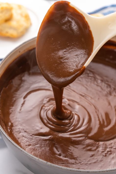 a plastic ladle holding up a scoop of chocolate gravy above a pot Choc Gravy Recipe, Crockpot Chocolate Gravy, How To Make Chocolate Gravy, Chocolate Gravy Recipe Easy, Homemade Chocolate Gravy, Southern Chocolate Gravy, Easy Chocolate Gravy Recipe, Chocolate Gravy Easy, Chocolate Gravy Recipe Southern