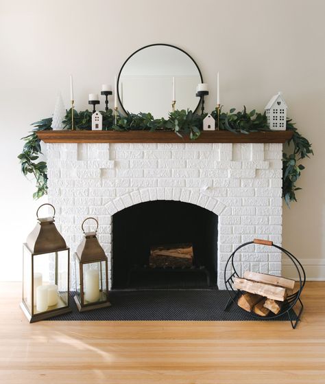 Holiday fireplace mantel, black and gold candle holders, white trees, and lanterns. Fireplace Lantern, Holiday Mantel Decor, Scandinavian Holidays, Lanterns Fireplace, Holiday Mantel, Holiday Table Decorations, Timeless Decor, Lanterns Decor, Fireplace Mantel