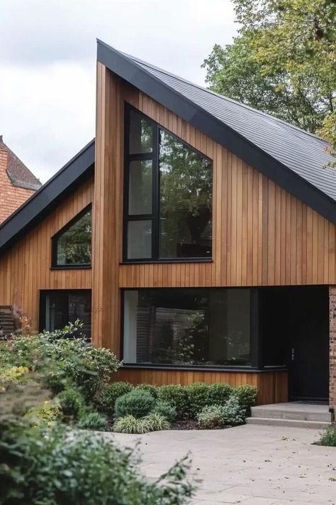 Timber clad modern house with gable roof bungalow style large black modern windows suburban front yard with shrubs. The chic, rustic charm of timber-clad houses might just be the trendiest look nobody warned you about. Gable Roof House Design, Modern Gable House, Modern Bungalow Exterior Design, Modern Gable Roof, Suburban Front Yard, House With Gable Roof, Modern House Black, Gable Roof House, Modern Bungalow Exterior