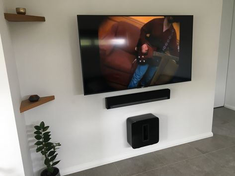 Wanted to achieve a modern clean cinema/hifi wall. Really pleased with the end result. I used a Sony Bravia 65 inch TV, a huge Sanus TV mount and some amazing Sonos speakers. The Sonos sound awesome. Plus a couple of feature Jarrah shelves. Tv Wall Design With Speakers, 65 Inch Tv Living Room Ideas, 65 Inch Tv Living Room Mounted, Modern Wall Ideas, 65 Inch Tv Living Room, Tv Living Room Ideas, Wall Mounted Tv Decor, Basement Rooms, Tv On Wall