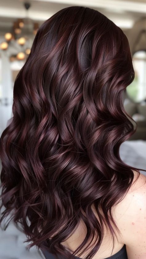 Wavy dark hair with rich burgundy highlights cascading down. Violet Brown Balayage, Easy Hair Color To Maintain Brunette, Brown Hair With Mocha Highlights, Chocolate Brown Hair With Babylights, Balayage To Brunette, Dark Brown Lowlights Brunettes, Warm Caramel Balayage Brunettes, Low Maintenance Brunette Hair Color, Rose Brown Hair Color