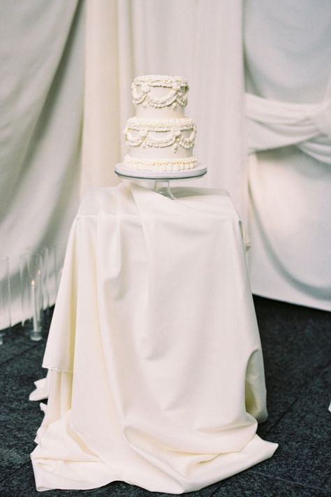 An elegant two-tier wedding cake with intricate lace-like decorations, displayed on a table draped in white fabric. White Piped Wedding Cake, Modern Minimalist Wedding, Cake Inspo, White Wedding Cake, Elegant Wedding Cakes, Wedding Cake Inspiration, Tiered Wedding Cake, Minimalist Wedding, Table Decoration